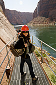 Eine junge Frau mit Schutzhelm und Rucksack auf einem Pfad entlang des Colorado River; Arizona Vereinigte Staaten Von Amerika