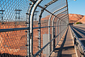 A Chain-Link Fence Running Along The Road At Glen Canyon Dam; Arizona United States Of America