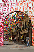 Eine Promenade zwischen den Geschäften, geschmückt mit einem Baldachin aus bunten Papierballons; Ronda Malaga Spanien