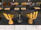 Goldene handgeformte Stühle und andere moderne Möbel in einer Hotel-Lobby