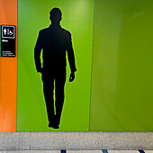 Silhouette einer männlichen menschlichen Figur an der Wand vor der Herrentoilette