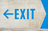 Großes blaues Exit-Schild auf weißer Wand