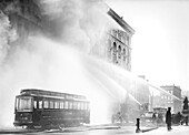 Feuerwehrmann, der Wasser auf ein brennendes Gebäude sprüht, 14th Street, New York City, New York, USA, Bain News Service, Dezember 1909