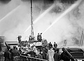 Fireman spraying water on burning building, 14th Street, New York City, New York, USA, Bain News Service, December 1909