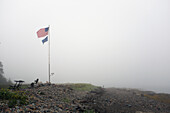Amerikanische Flagge weht im Wind am nebligen Strand