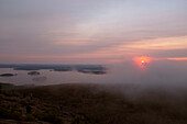 Gruppe von Menschen, die den Sonnenaufgang vom Cadillac Mountain aus beobachten, Maine, USA