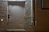 White Metal Door and White Brick Wall Exterior at Night