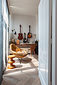 View of the room with vintage leather armchair, desk and guitar collection