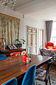 Antique wooden table, shelf in the background and wall hanging in the dining area