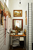 Vintage trolley with towels and soaps in narrow room with art collection