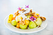 Melon and mango fruit salad with walnuts and coconut