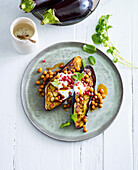 Baked eggplant topped with pomegranate and chickpeas