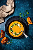 Pumpkin-coconut milk soup with pomegranate and parsley