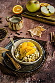 Autumnal oatmeal with cinnamon, apples and orange