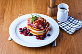 Pancakes with various berries and bacon