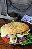 Focaccia-Sandwich mit Eiern, Tomaten und Zwiebeln