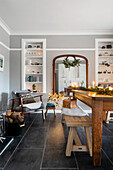 Living room with log fire, retro armchair, mirror and festive Christmas decorations