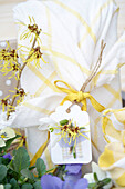 Gift with spring flowers in yellow and white cloth and pendant