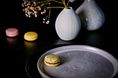 Still life with macarons, ceramic plate and vase
