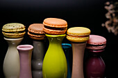 Macarons on colourful ceramic vases