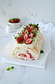 Meringue roll with fresh strawberries and vanilla cream cheese frosting
