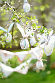 Easter eggs and garlands as spring decorations in the garden