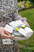 Table setting items with spring motif and daffodils (Narcissus) in the garden