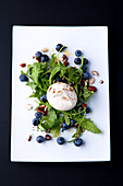Burrata on rocket salad with blueberries and hazelnuts