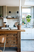 Bright and modern kitchen area with rustic kitchen block and green plant accents