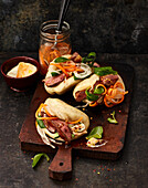 Sticky pigeon breast with pickled carrots in bao buns