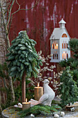 Weihnachtsdeko mit gebundenem Minitannenbäumchen, Kerzen und Taube