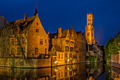 Belgium, Bruges. Buildings reflect in canal at twilight.