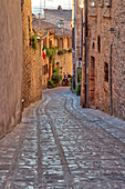 Italy, Umbria. Cobblestone street in the town of Spello.