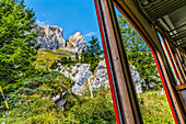 Colorful cogwheel rail car climbing Mount Pilatus, Lucerne, Switzerland.