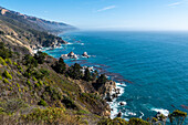 The rugged coastline of Big Sur with wisps of fog drifting into the hills.