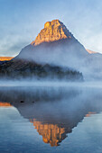 Sinopah Mountain und nebliger Sonnenaufgang über dem Two Medicine Lake im Glacier National Park, Montana, USA