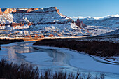 USA, Utah. Die Fisher Towers, die La Sal Mountains und die Canyonwände spiegeln sich im eisigen Colorado River.