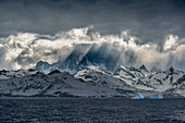 South Georgia Island. Opening in clouds and Virga reveal the mountainous and glaciated landscape.