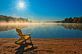 Kanada, Ontario, Silent Lake Provincial Park. Muskoka-Stuhl und Morgennebel am Silent Lake.