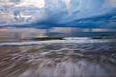 USA, Georgia, Tybee Island. Sonnenaufgang mit Wolken und Reflektionen entlang der Küste.