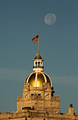 USA, Georgia, Savannah. Monduntergang über der goldenen Kuppel des Rathauses.