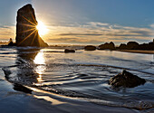 USA, Oregon. Cannon Beach low tide and ripples in the sand and sea stacks at sunset.