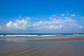 Beach And Clouds Over Water