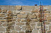Leiter auf Steinmauer