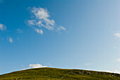 Wolken über einem Hügel