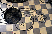 Schatten eines Stuhls auf gefliestem Boden