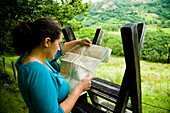 UK, Snowdonia National Park; North Wales, Woman reading map; Nantgwynant