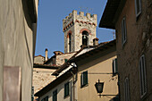 Glockenturm der Kirche von der Hauptstraße im Zentrum von Radda in Chianti, einer schönen kleinen Stadt und einer berühmten Region, die für ihren Chianti-Wein bekannt ist, in der Toskana. Italien. Juni.