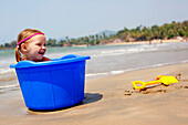 Isla Reynolds im Alter von 4 Jahren spielt mit Eimern und Spaten am Patnum Strand, Goa, Indien.