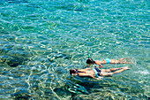 Mädchen beim Schnorcheln in den klaren Gewässern von Cala Sant Pere, Alcudia, Mallorca, Balearen, Spanien